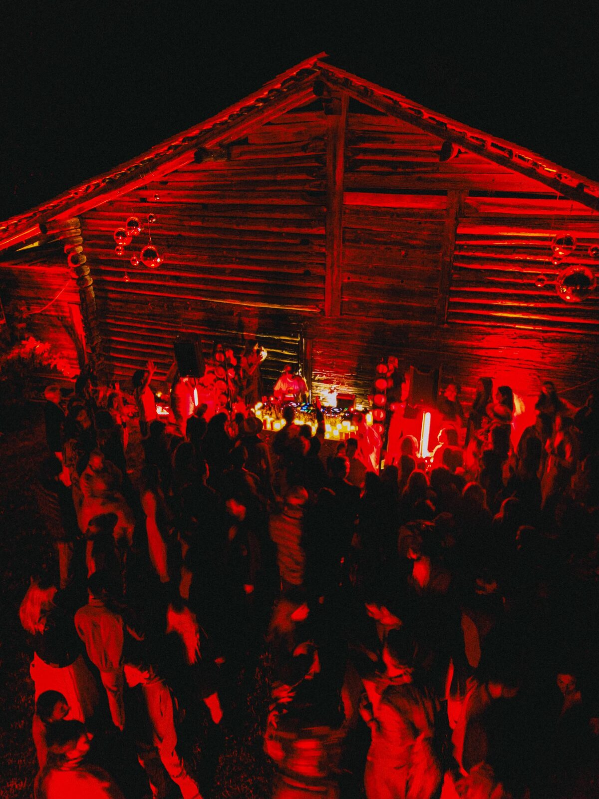 Dancing at a wooden chalet bathed in red light
