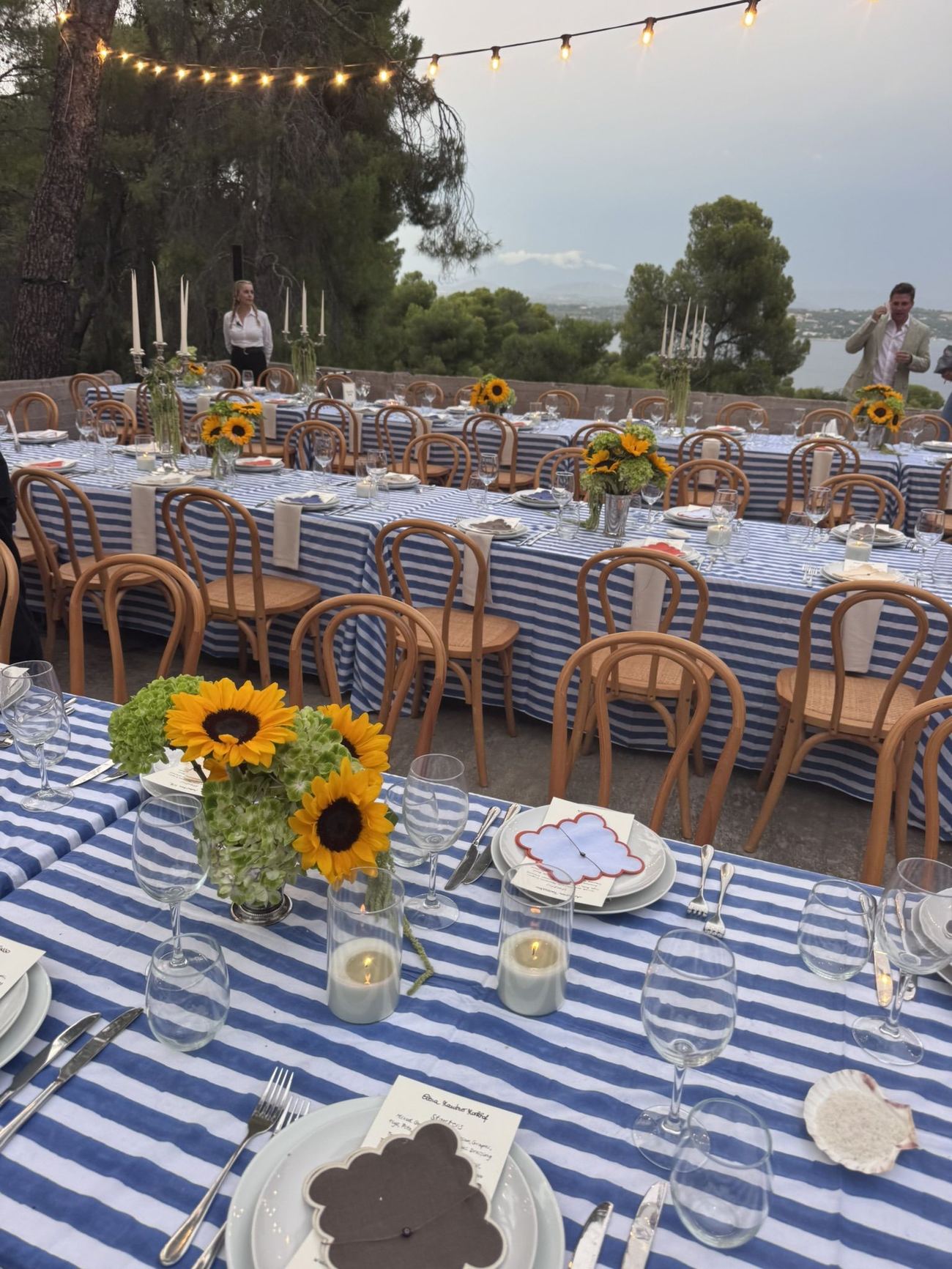 Long table with sunflowers under string lights